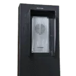Close-up of a black Avio Technologies outdoor speaker post with a brushed metal intercom panel and mounting screws.